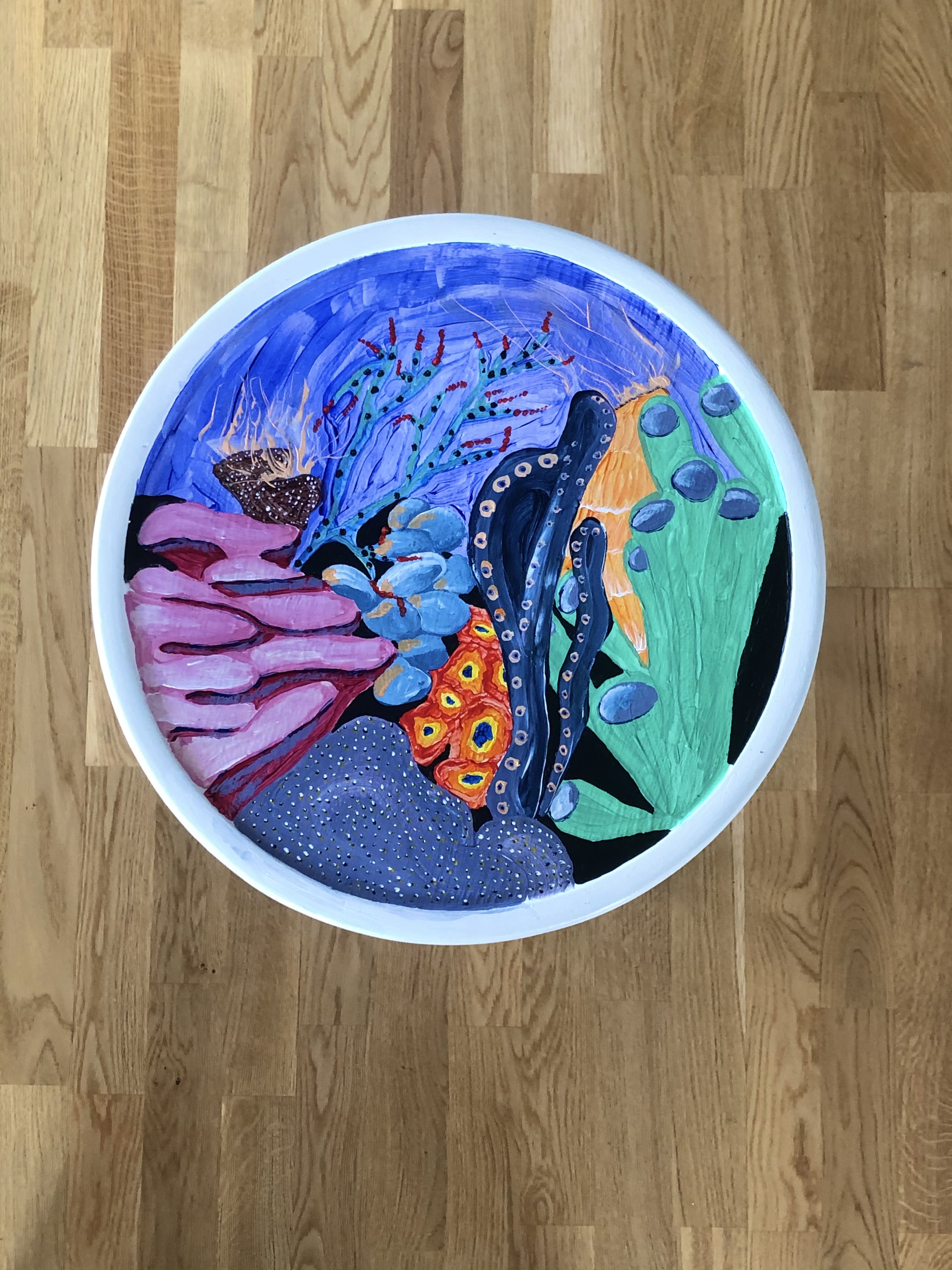 white stool with underwater scene painted on top of it from another angle